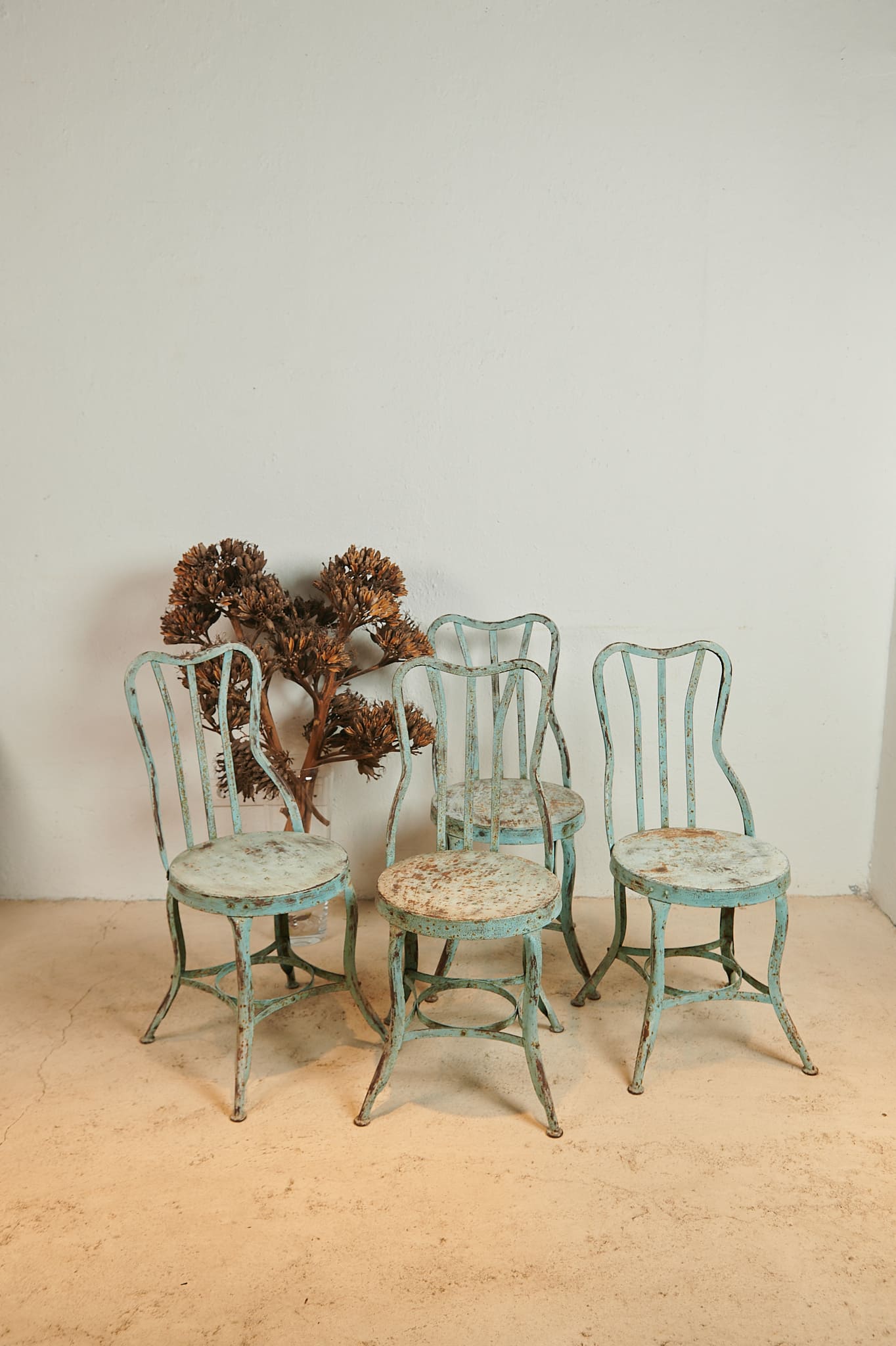 Conjunto de cuatro sillas metálicas con pátina azul verdosa